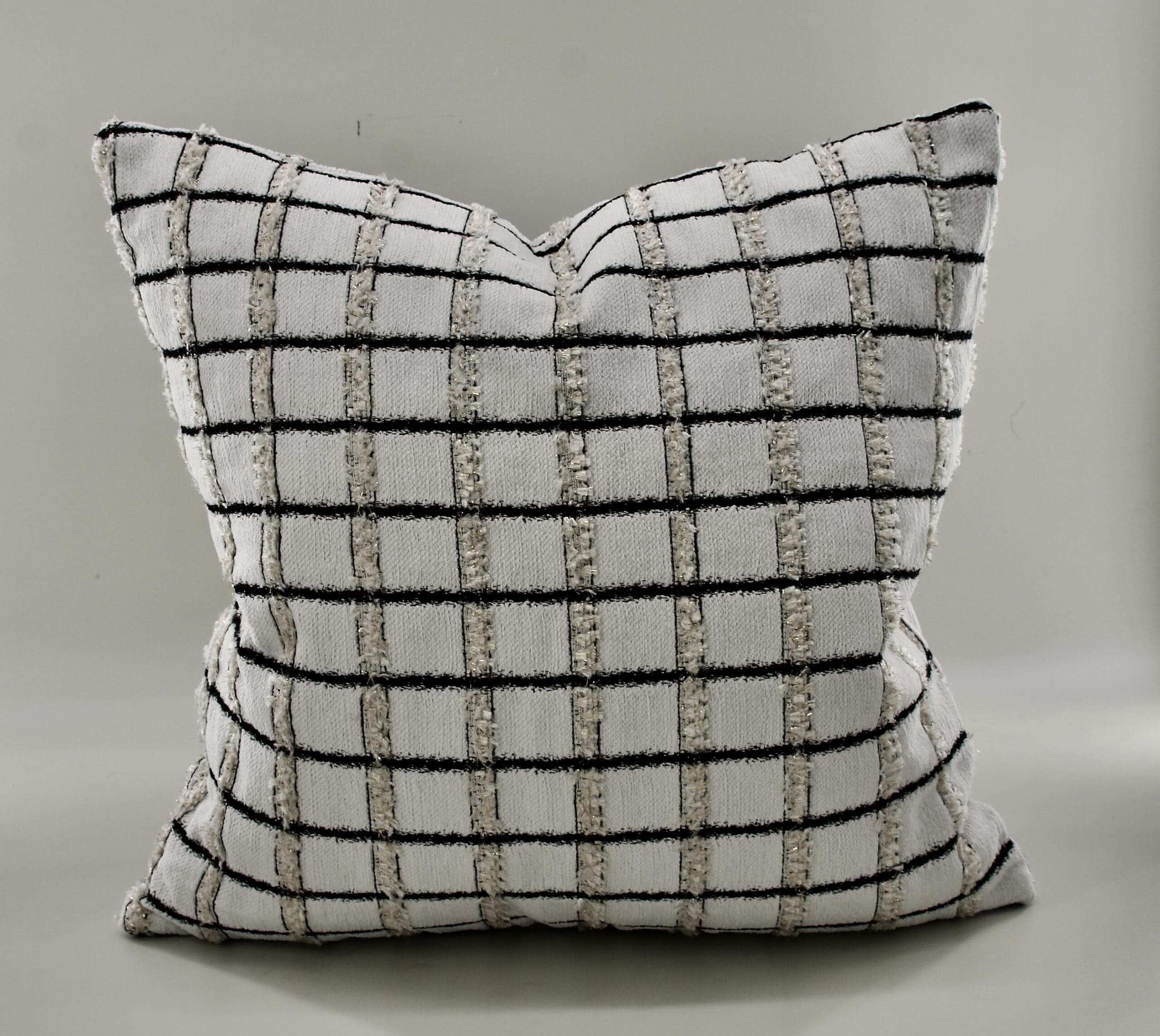 Textured throw pillow in a grid pattern of black and cream, showcasing a modern and stylish accent for home decor.